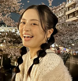 夜桜をバックに笑顔の女性